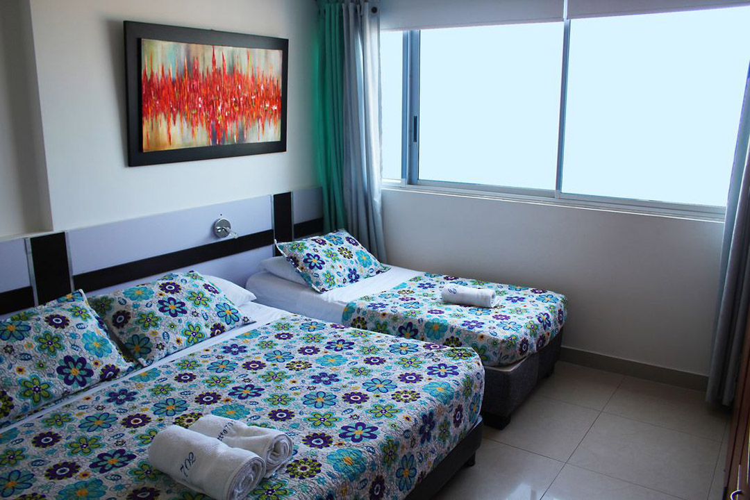 habitacion con una cama doble y una cama sencilla en apartamento turistico en cartagena