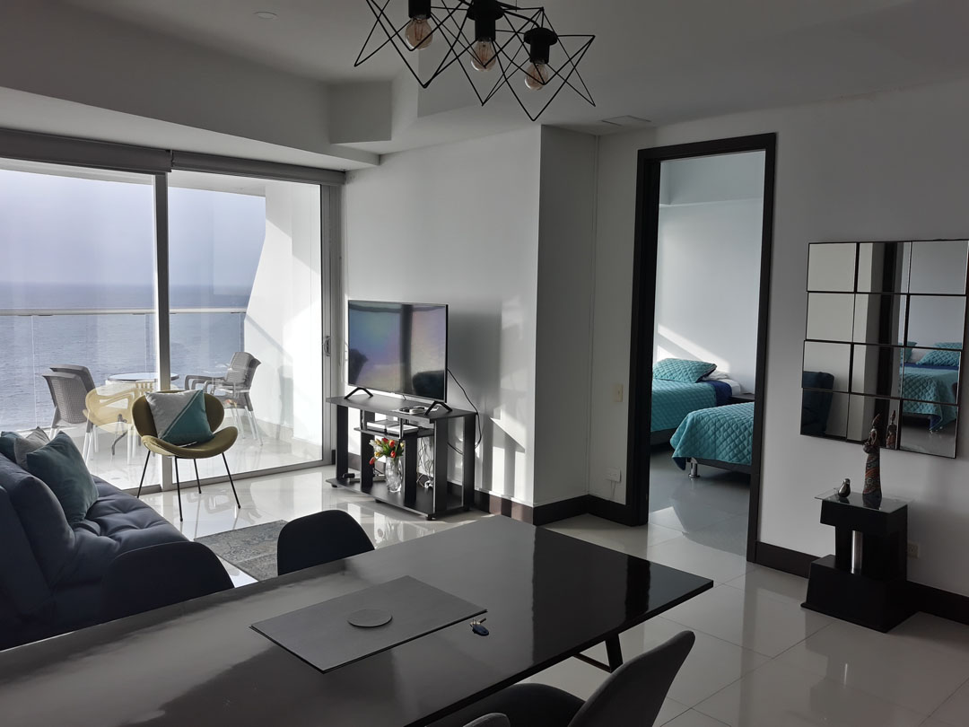 apartamento con decoración moderna que incluye al comedor, la sala de estar, una habitación y balcón que da vista al mar