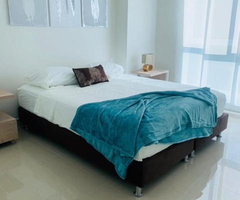 habitación de estilo elegante equipada con cama doble y 2 nocheros, su ventana piso techo tiene cortina estilo panel japonés