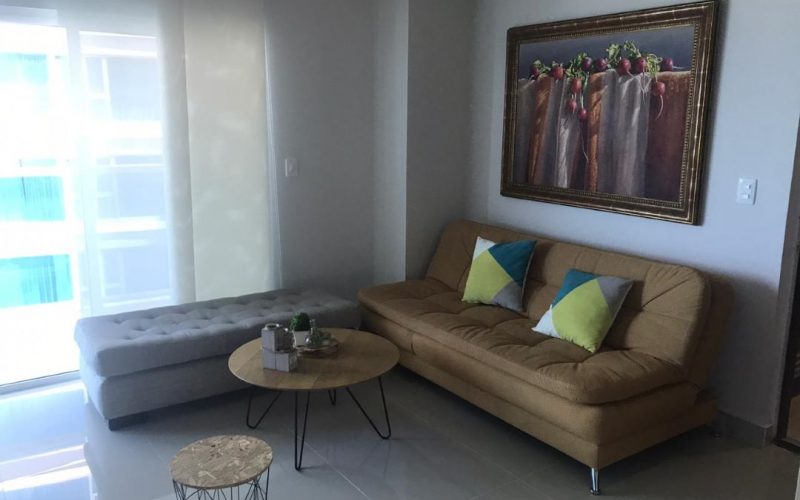sala de estar con diván y sofacama, mesa de café y silla otomana de estilo industrial, ventana con vista exterior