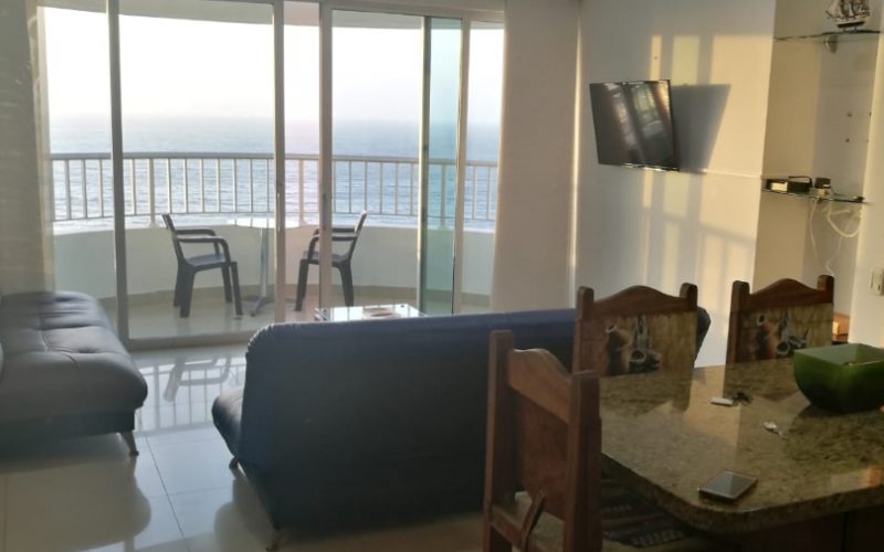 apartamento en Cartagena con comedor tipo isla para tres personas, sala amoblada con sofás y salida a balcón con vista al mar