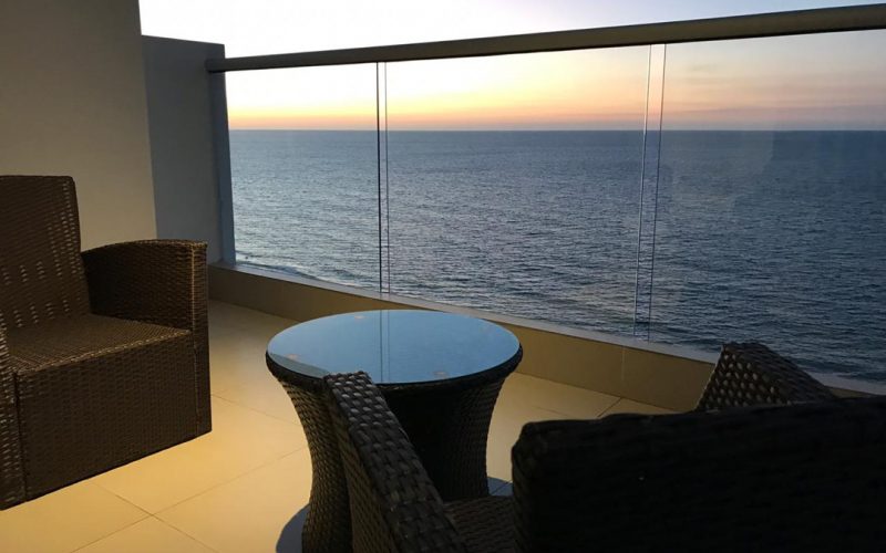 sillas y mesa de centro en mimbre cafe oscuro en balcon con vista al mar