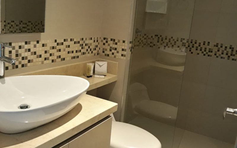 baño completo de color beige con lavamanos y sanitario color blanco