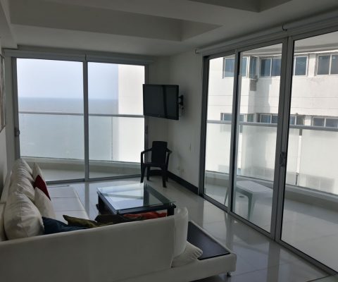 sala de apartamento con muebles, tv en pared y salida a amplio balcón con vista al mar de Cartagena