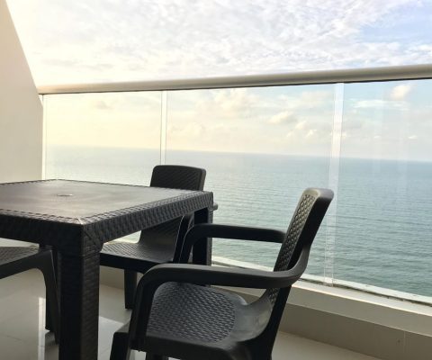 desde un balcón amoblado con muebles plásticos se puede ver hasta el horizonte del mar tranquilo de Cartagena