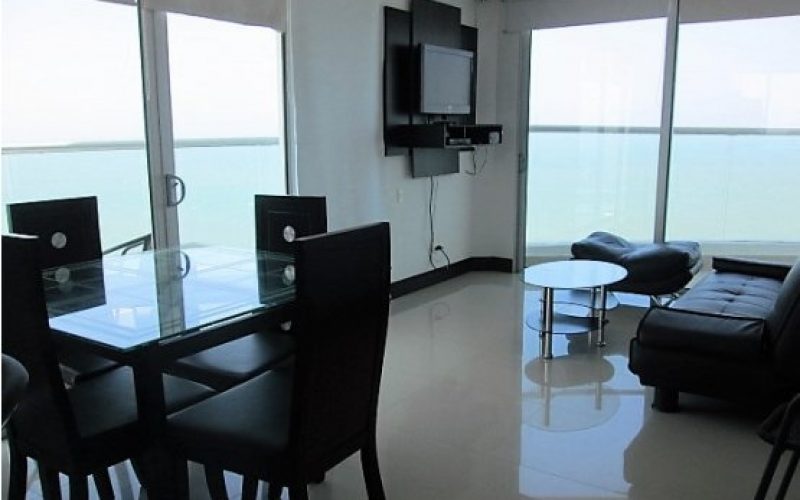 sala comedor con pisos en ceramica color gris claro y sillas en cuero color negro mesa en vidrio y televisor