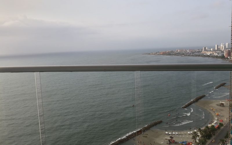 desde un balcón se ve la playa de Bocagrande en Cartagena y a lo lejos se distingue parte de la ciudad amurallada