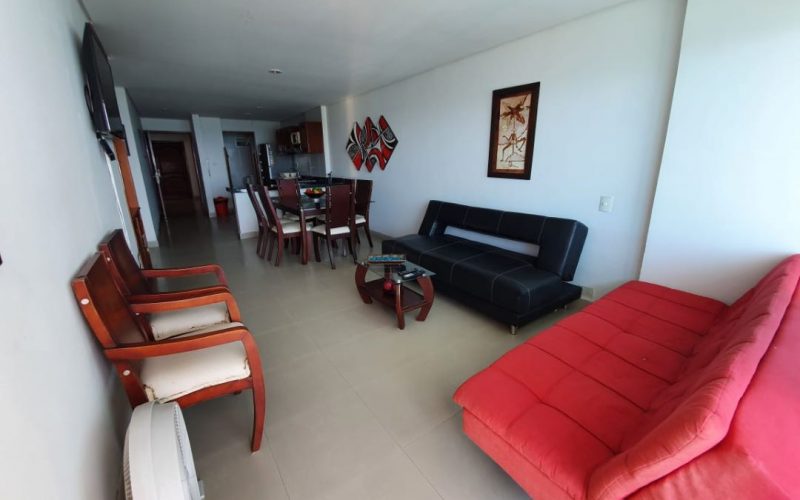 sala compuesta de dos sillas de madera, un sofa en cuero color negro, un sofa color rojo y una mesa pequeña de centro