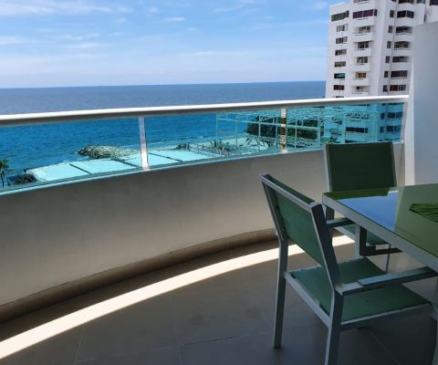 balcon con vista al mar y mesa en madera color blanca y verde